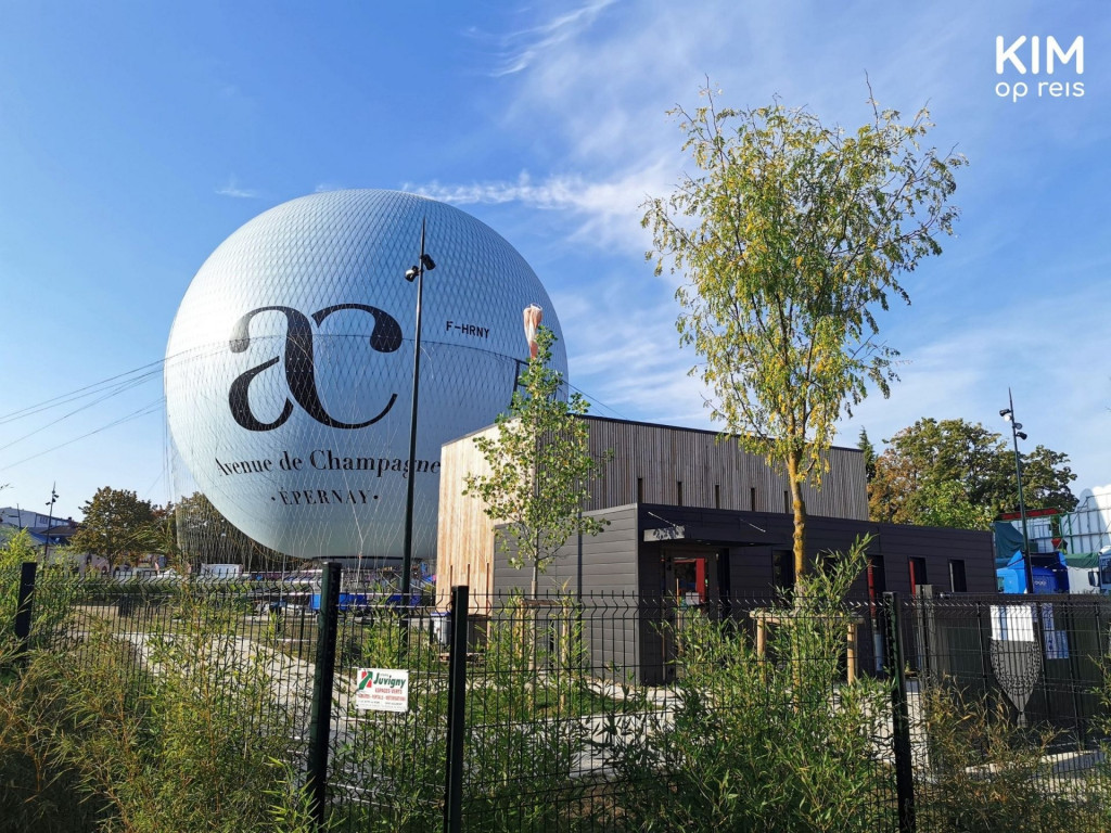 luchtballon Epernay: enorme witte luchtballon met AC Avenue Champagne erop, rust op de grond