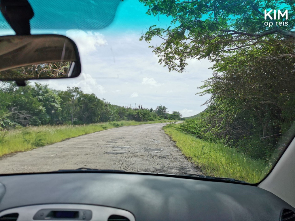 hobbelige weg naar Porto Marie: foto van slecht wegdek vanuit de auto